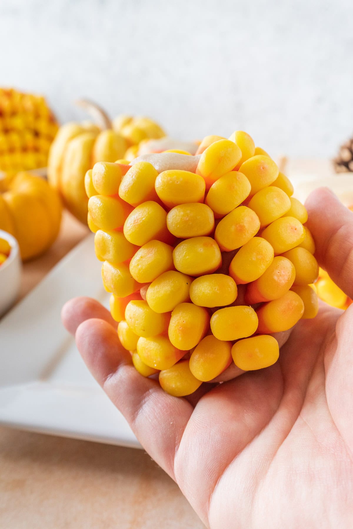 Holding candy corn on the cob, showing the side  and all the kernel rows.
