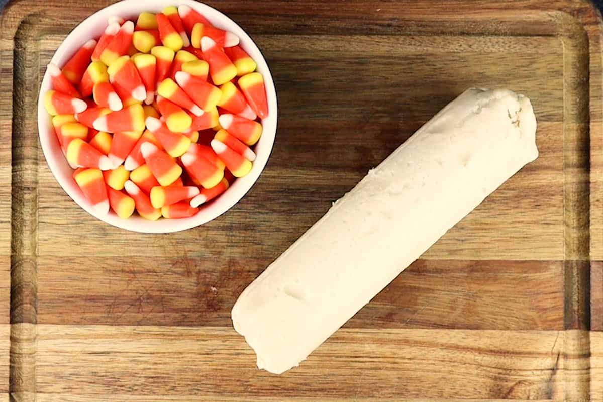 cookie dough and candy corn in cutting board