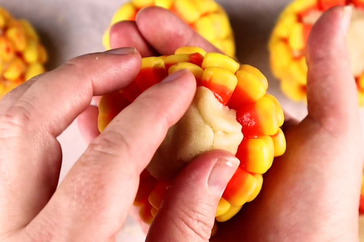 fixing the dough on the ends of the candy corn on the cob