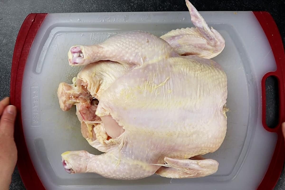 whole raw chicken on cutting board