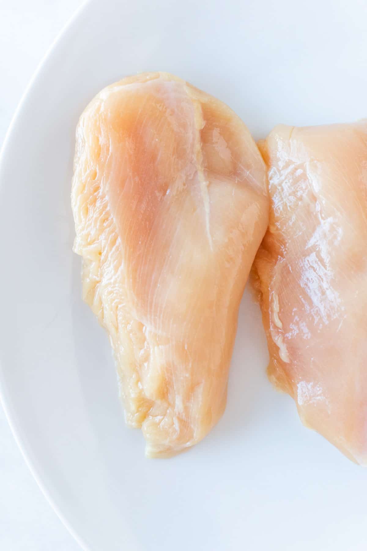 Raw chicken breast on plate