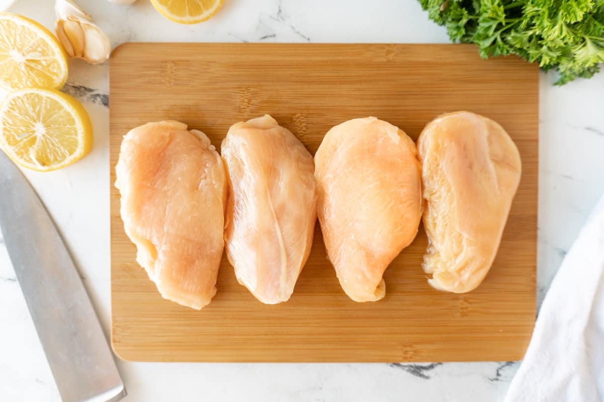 raw chicken breasts on cutting board