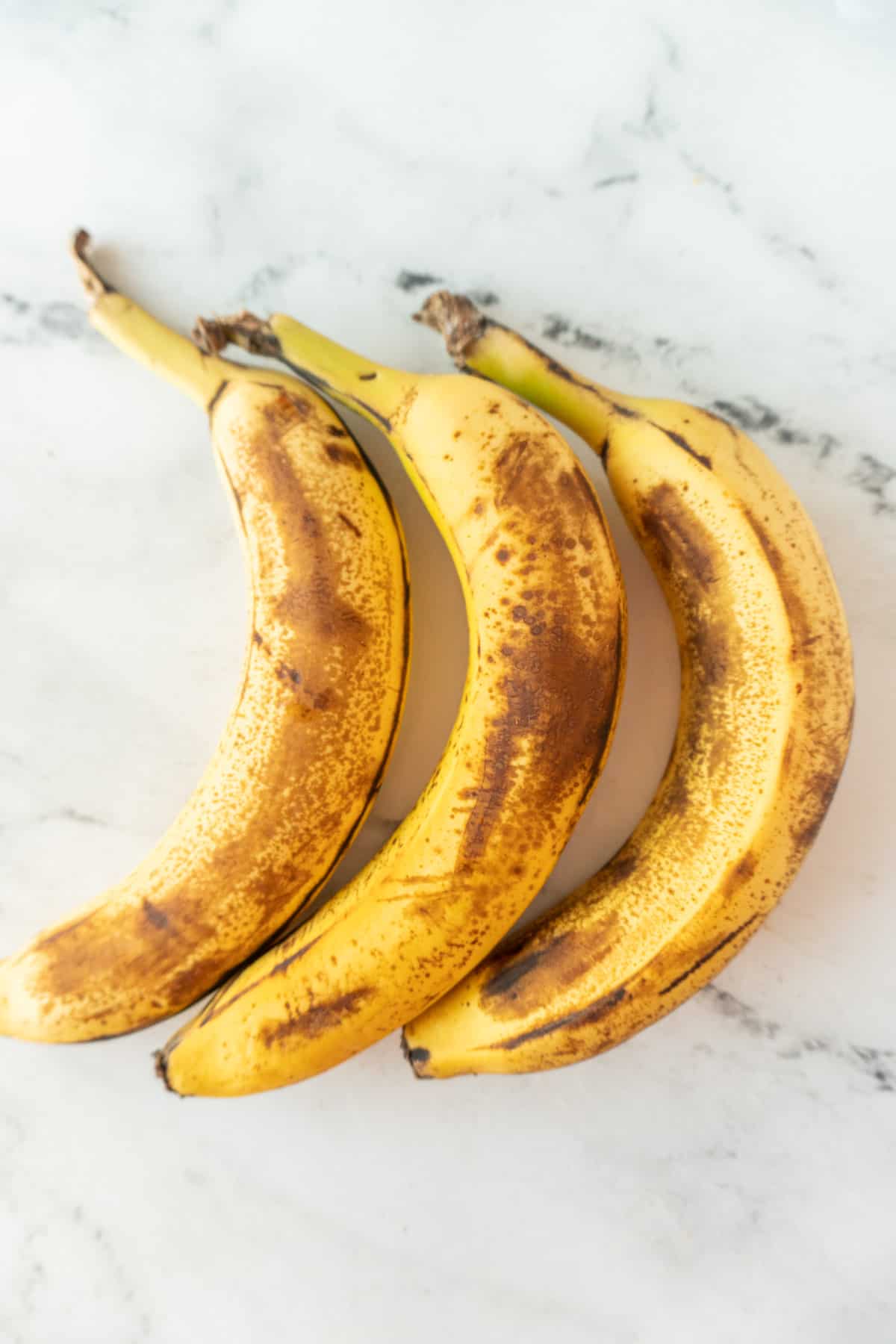 3 brown bananas with peel on