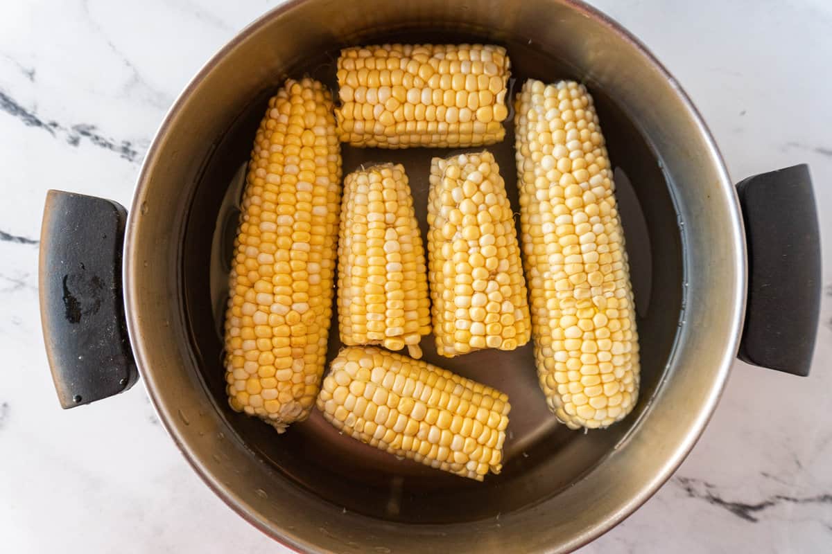 corn on the cob in pot before blanching