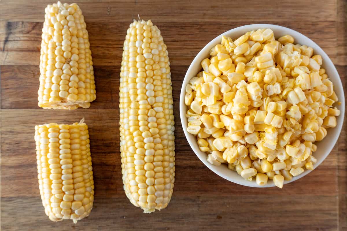 corn on the cob whole and cut in hald, and bowl of corn kernals