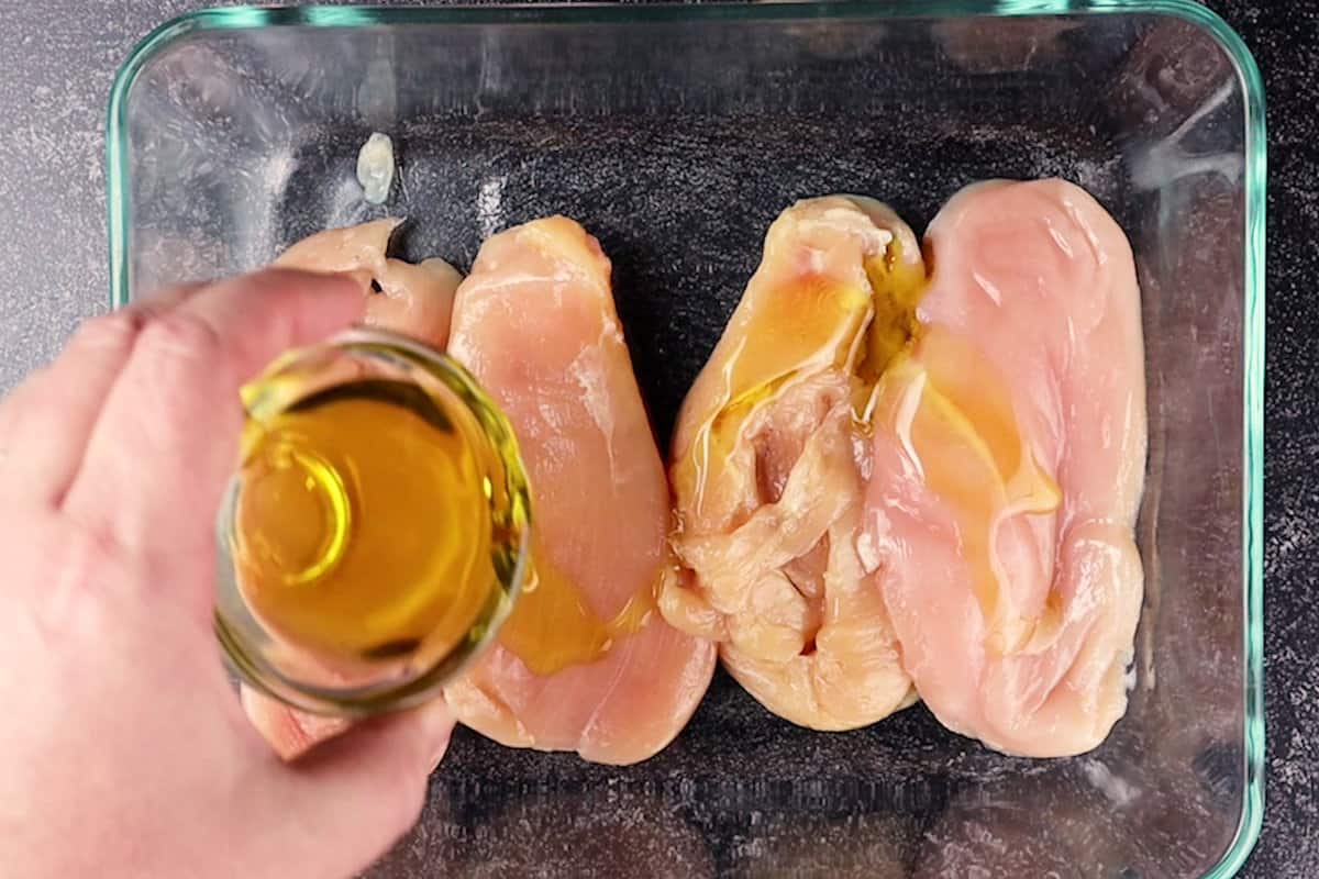 adding oil to chicken breast