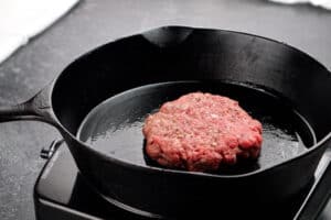 adding wagyu burger Patty to pan