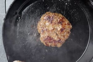 Wagyu burger being cooked in pan