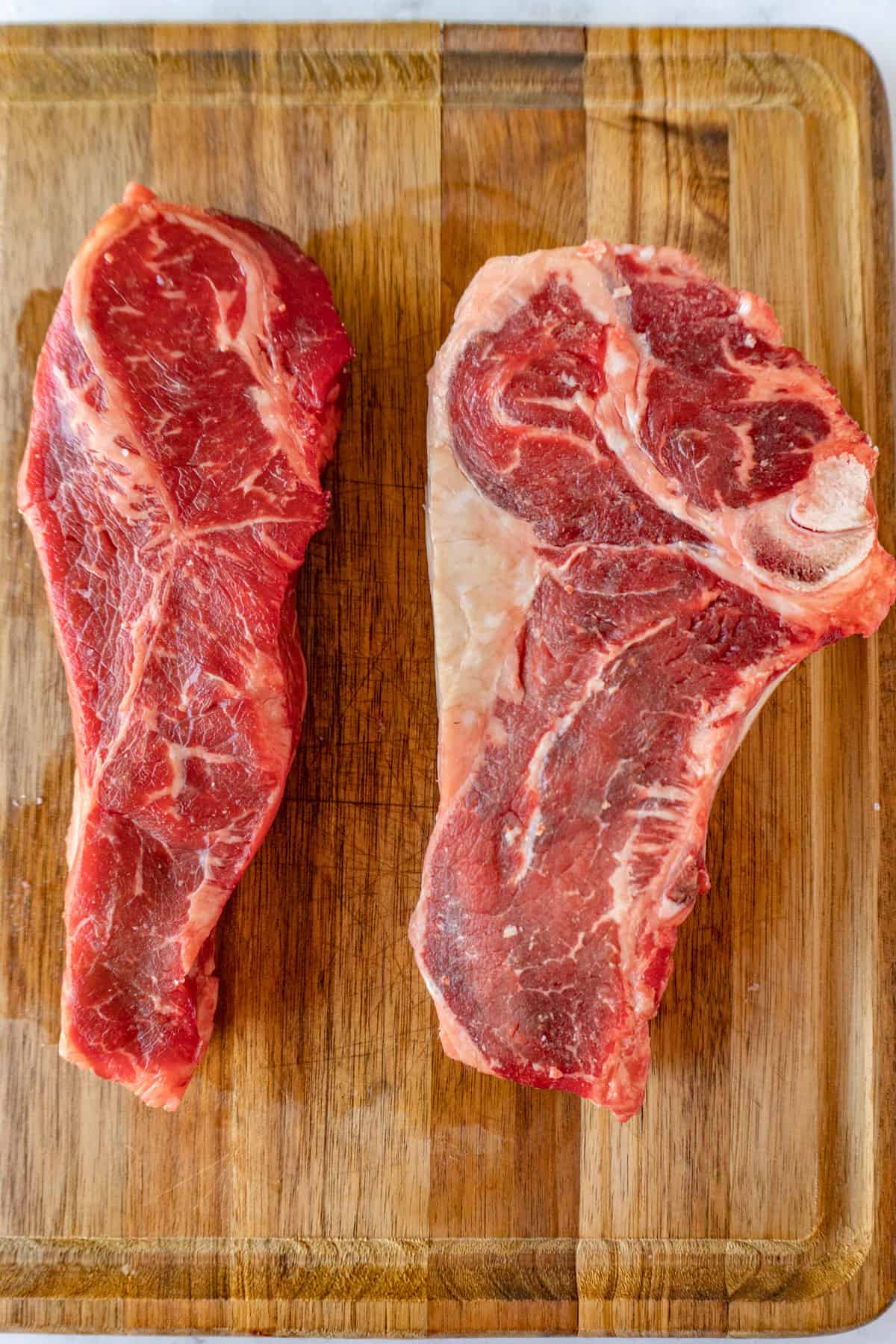 New York Strip and Ribeye on cutting board