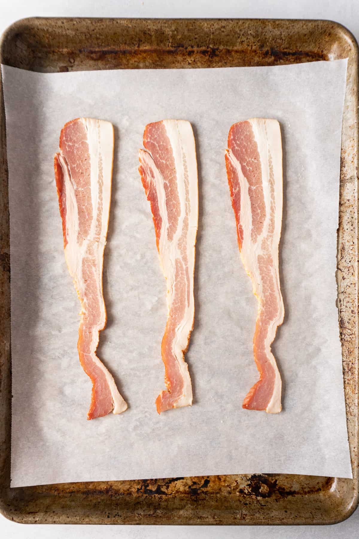 raw bacon on parchment paper