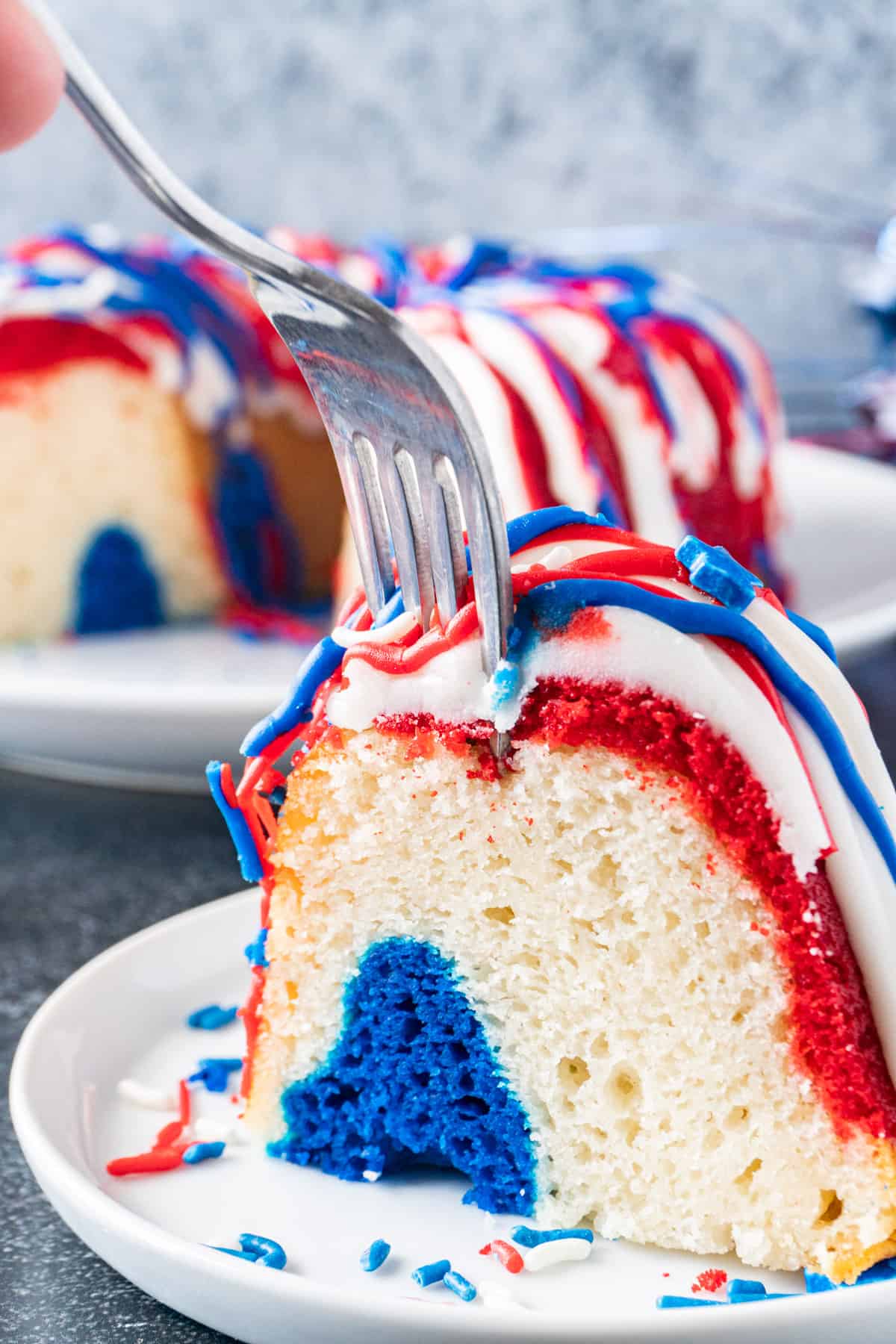 cutting into a slice of cake with a fork