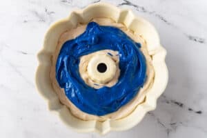 adding blue batter to bundt pan