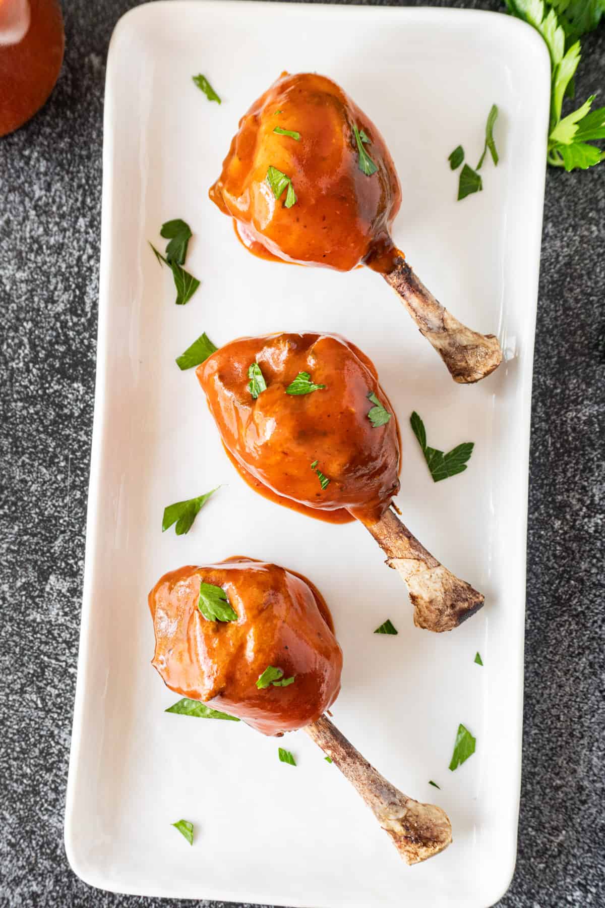 chicken lollipops dipped in bbq sauce on platter