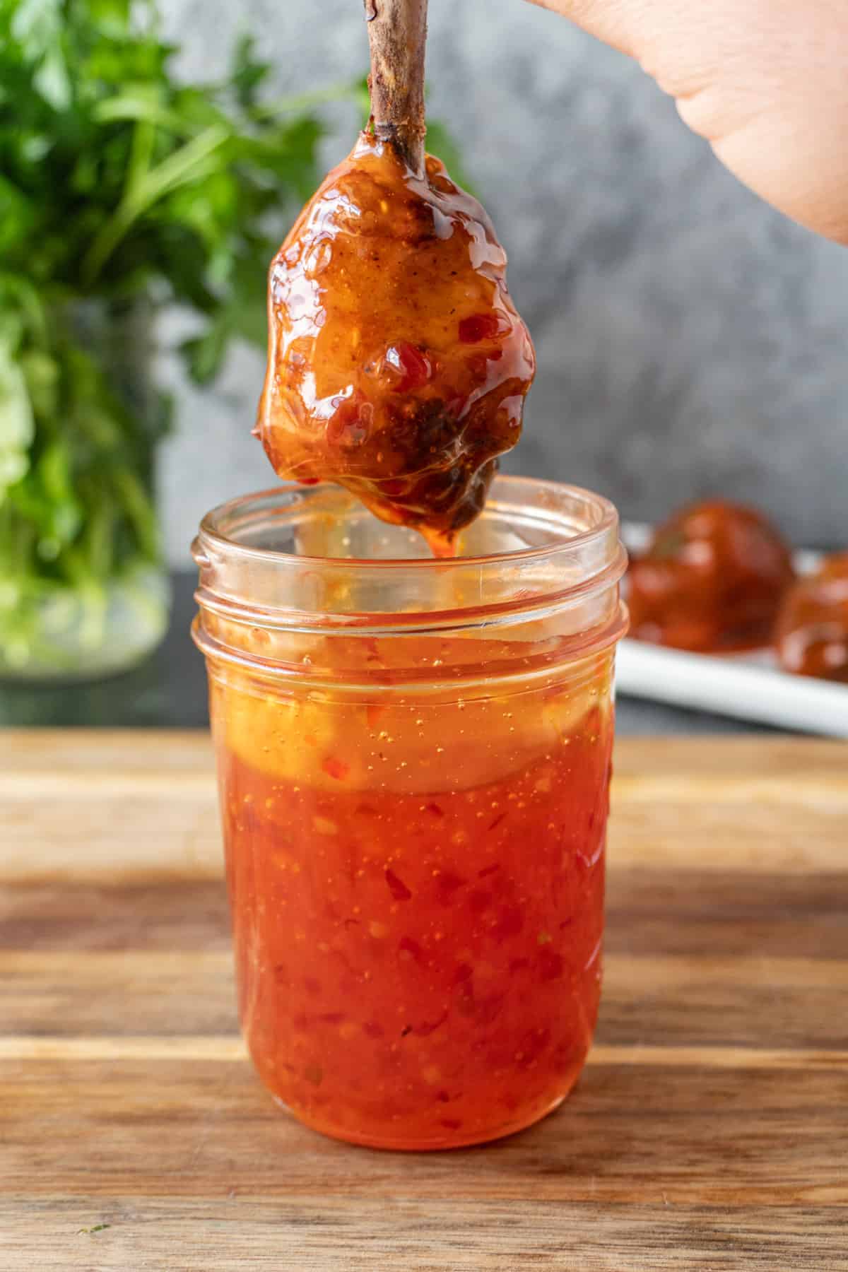 dipping a chicken lollipop in asian sauce