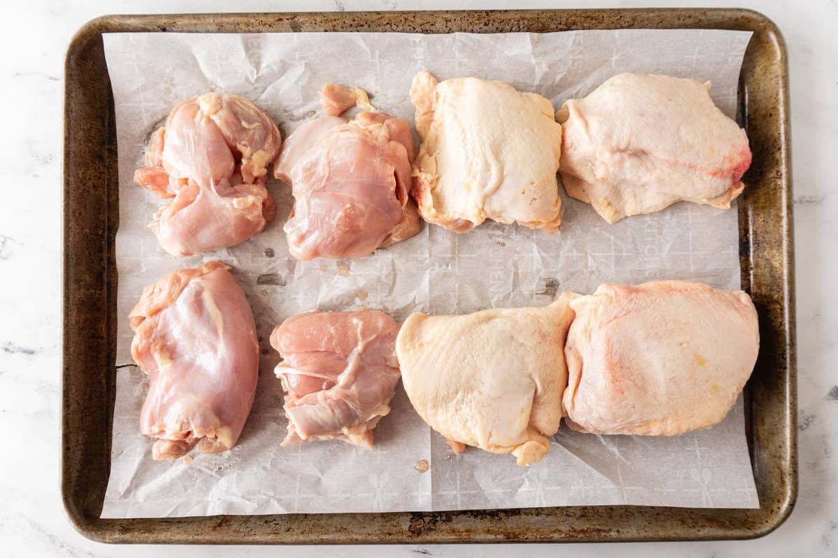 raw chicken thighs on baking sheet