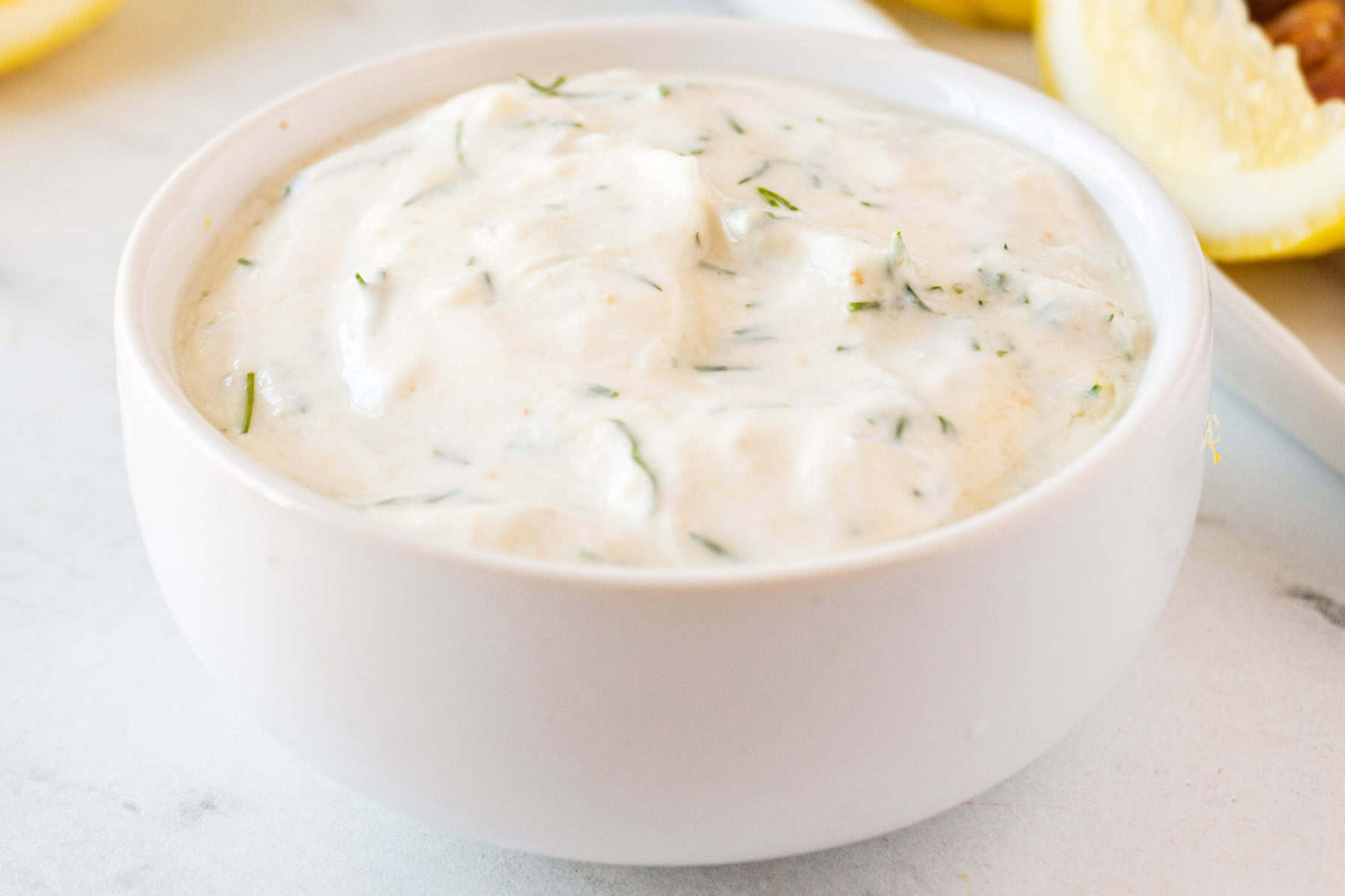 lemon dill yogurt dip in white bowl