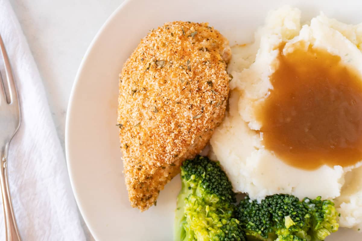 shake and bake chicken on plate next to mashed potatoes and broccoli