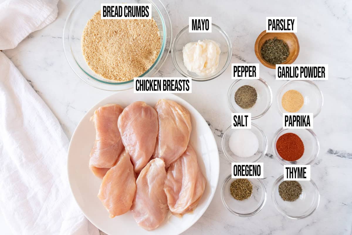 homemade shake and bake chicken ingredients in individual bowls on marble background.