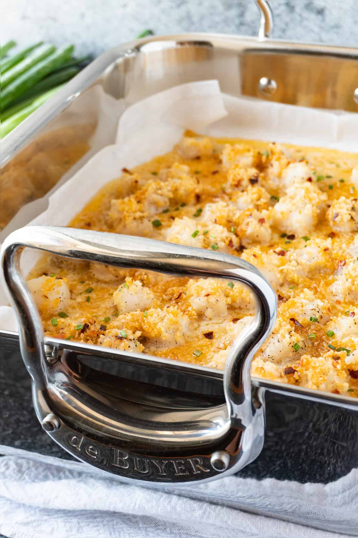 baked scallops in roasting pan next to green onions