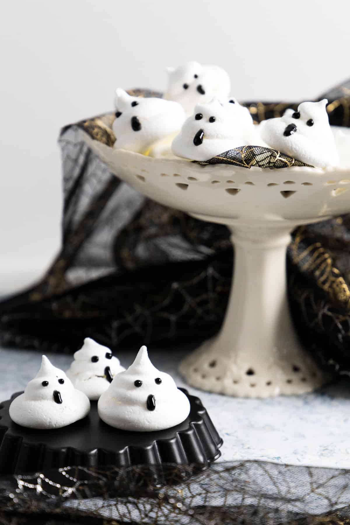 ghost meringues on plate and cake stand