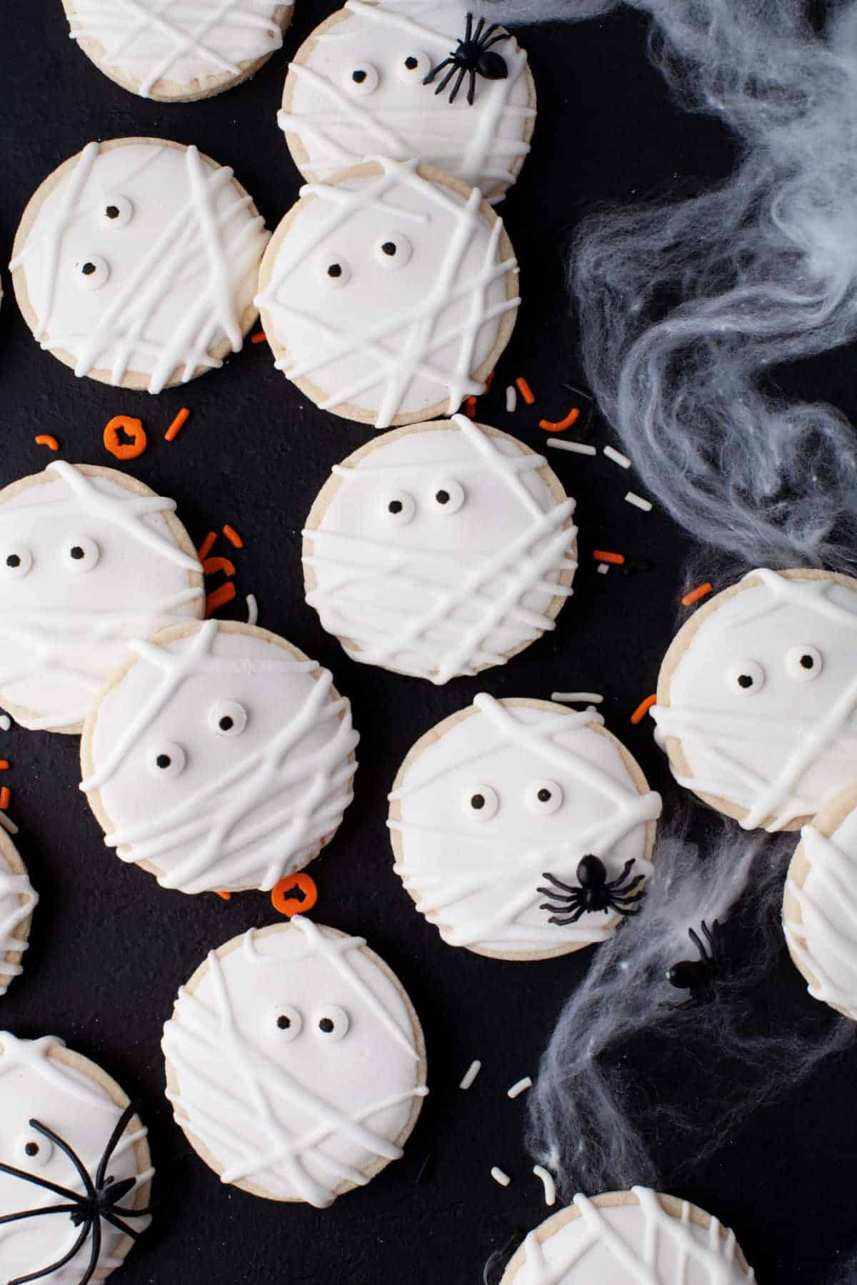 sugar cookies that look like mummies next to Halloween decoration