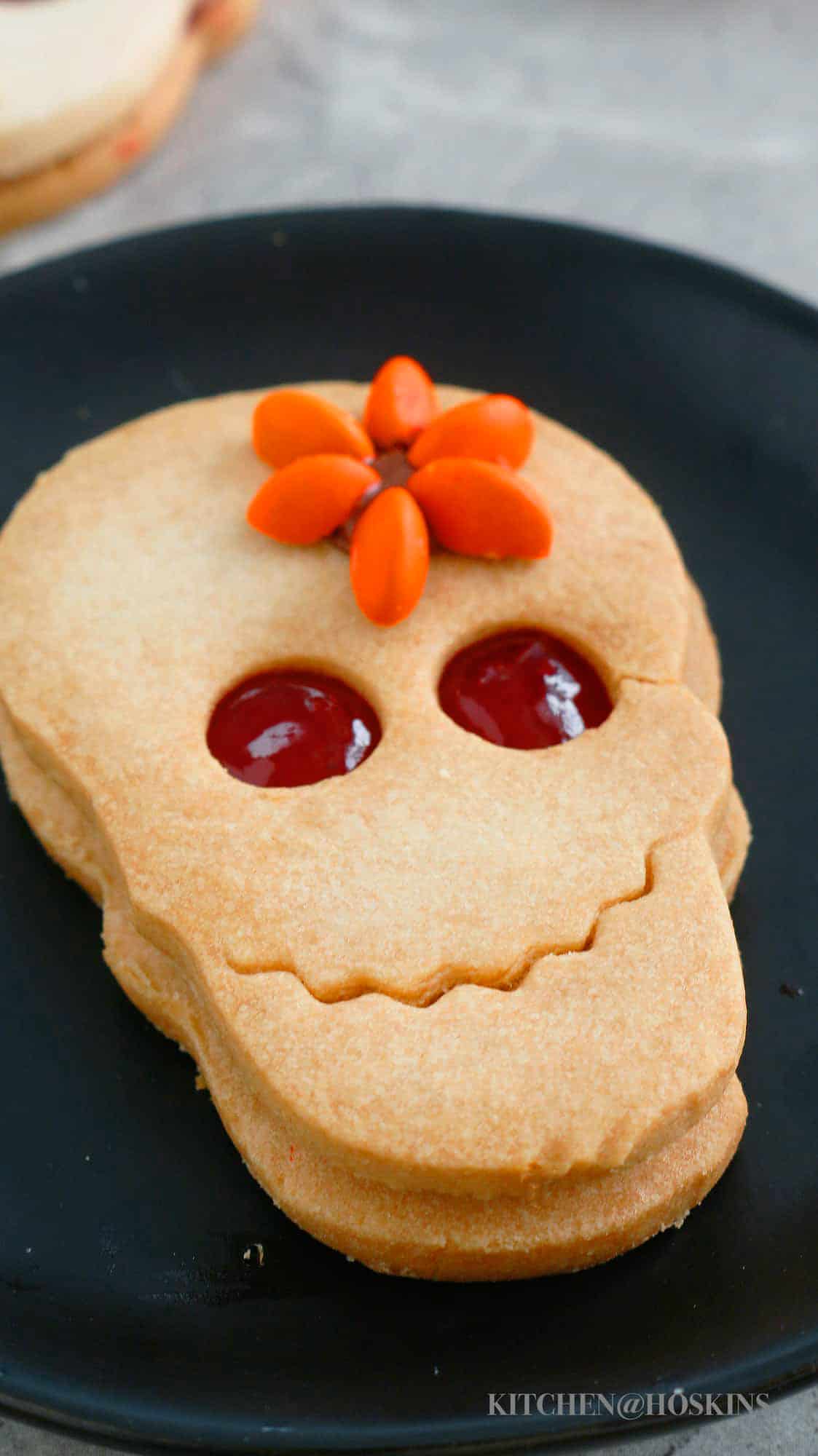 skull linzer cookie on black plate