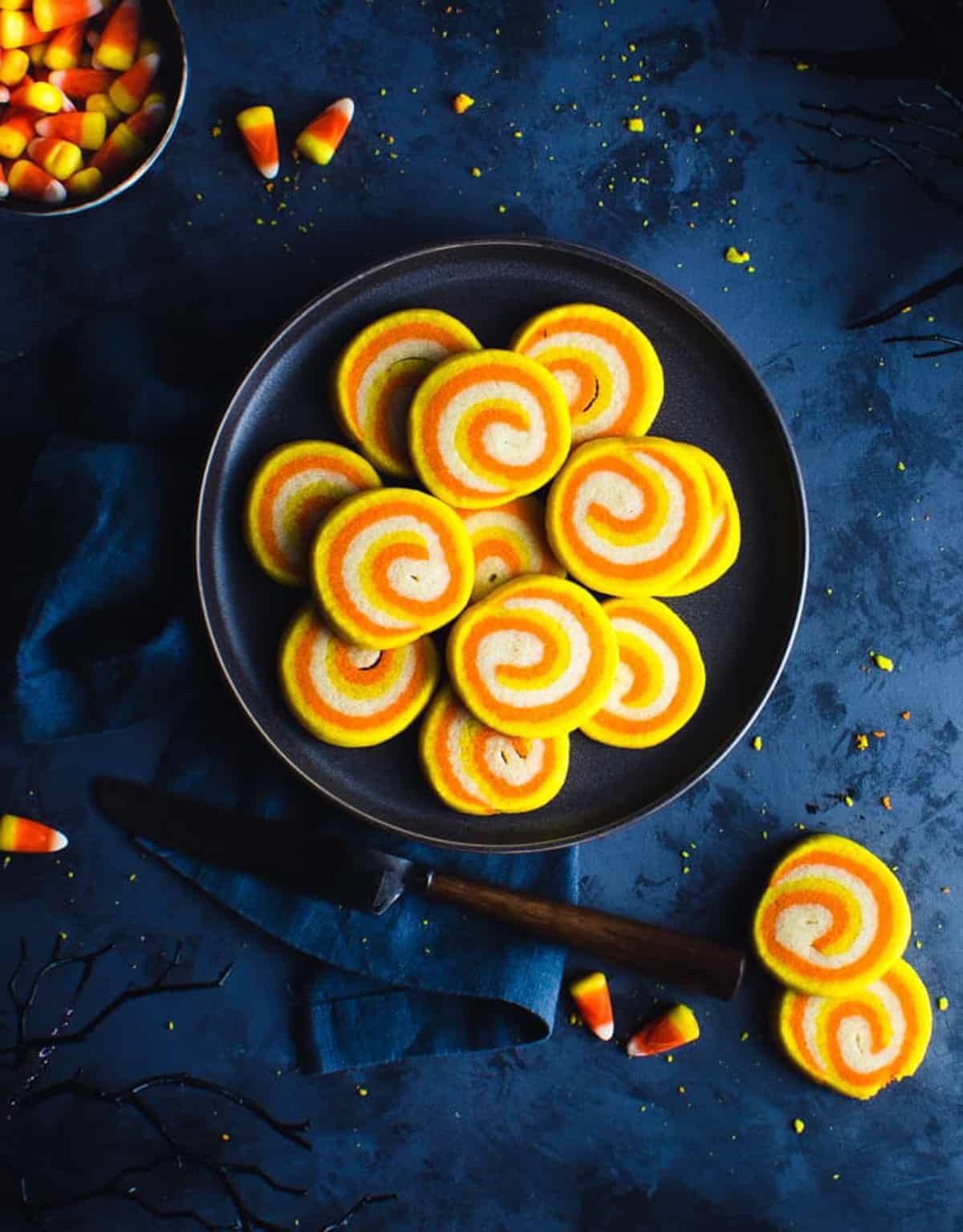 candy corn pinwheel cookies on black plate