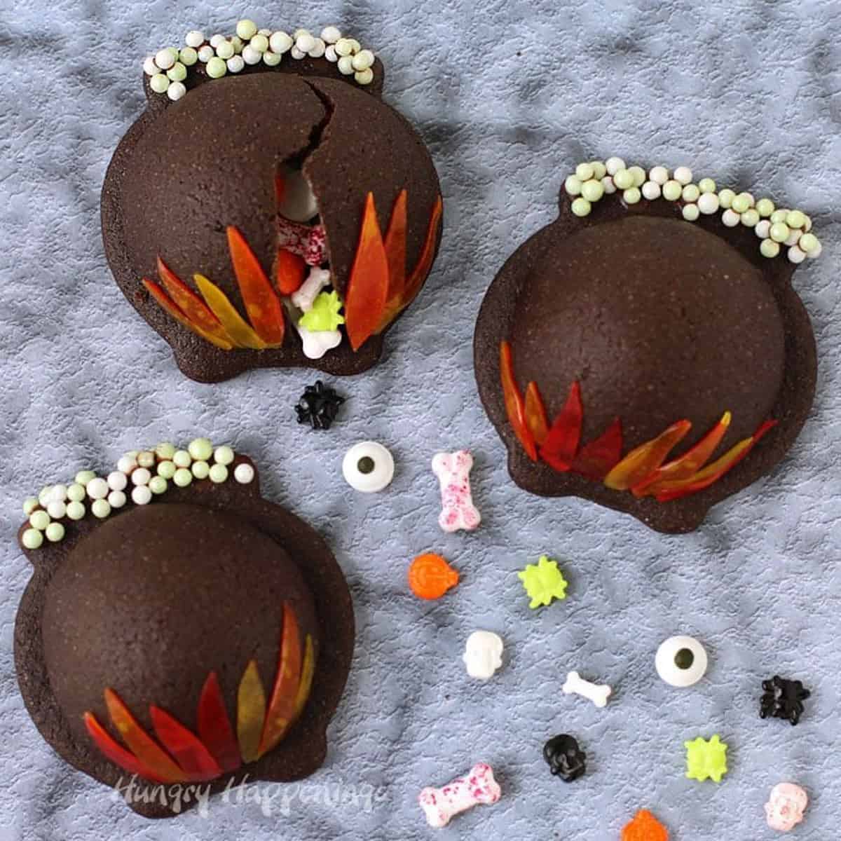 cookies shaped like cauldrons with sprinkles spilling out