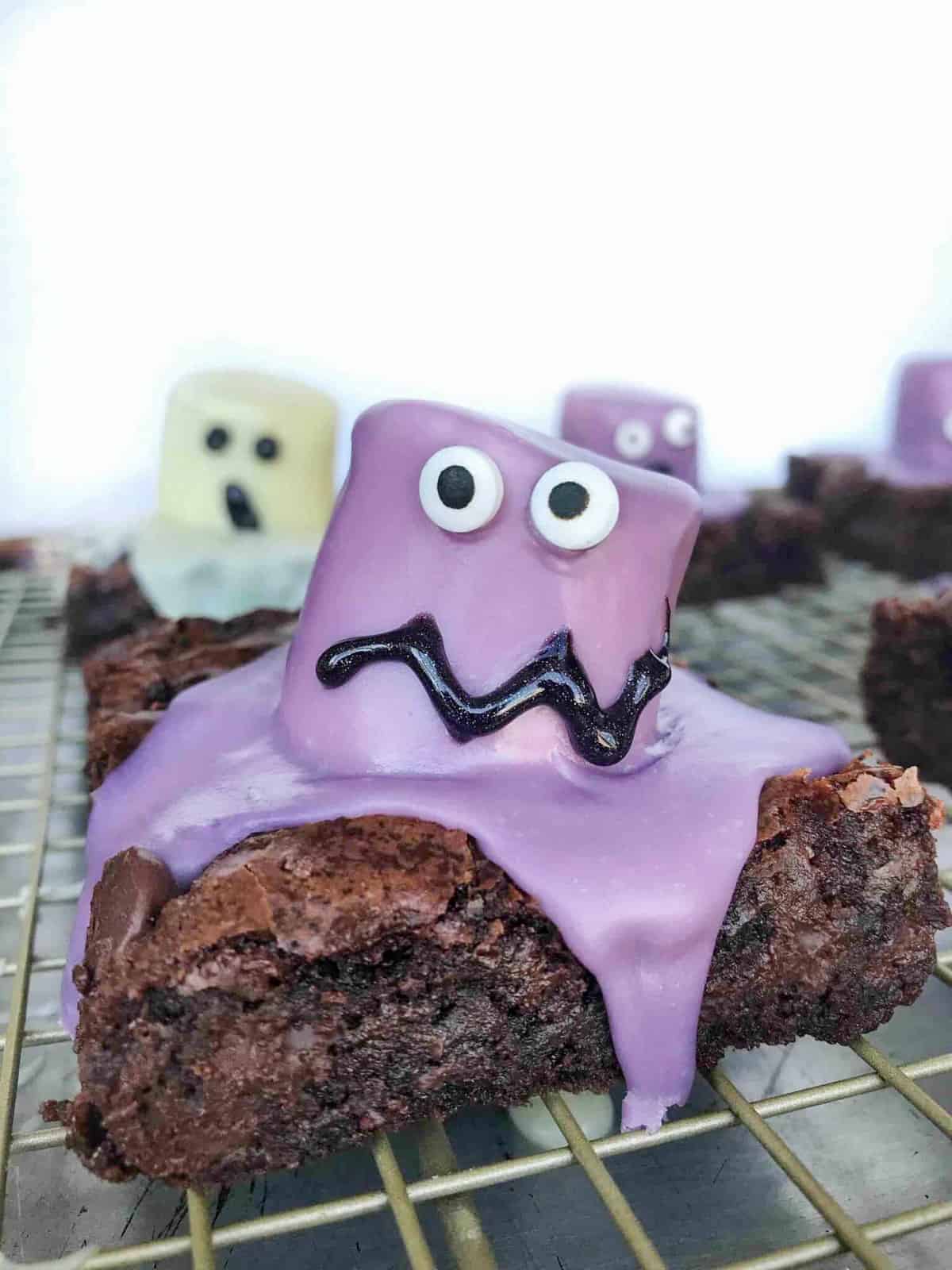 brownies with marshmallow monsters covered in purple melted candy