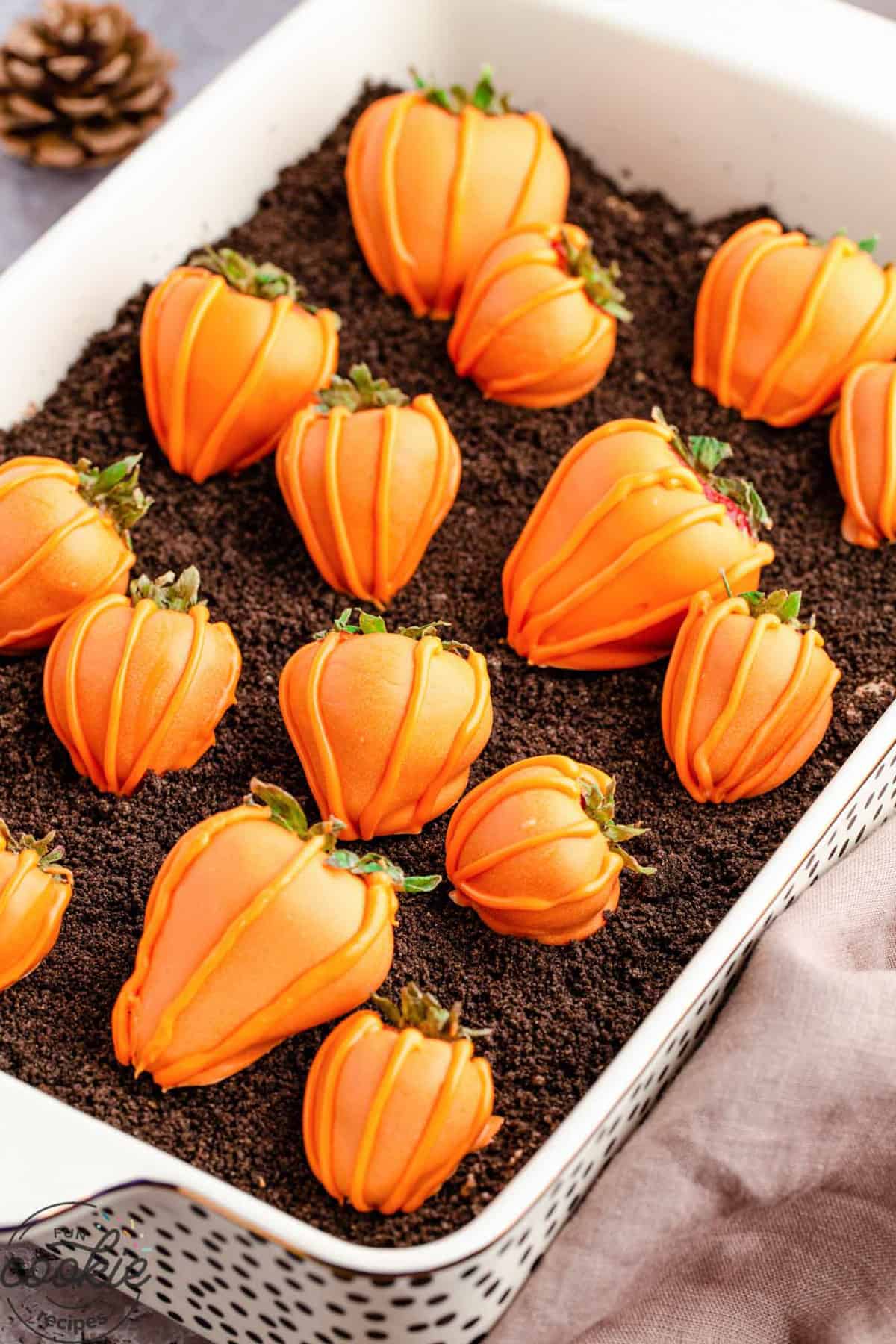 brownies with orange candy coated strawberries decorated to look like pumpkins