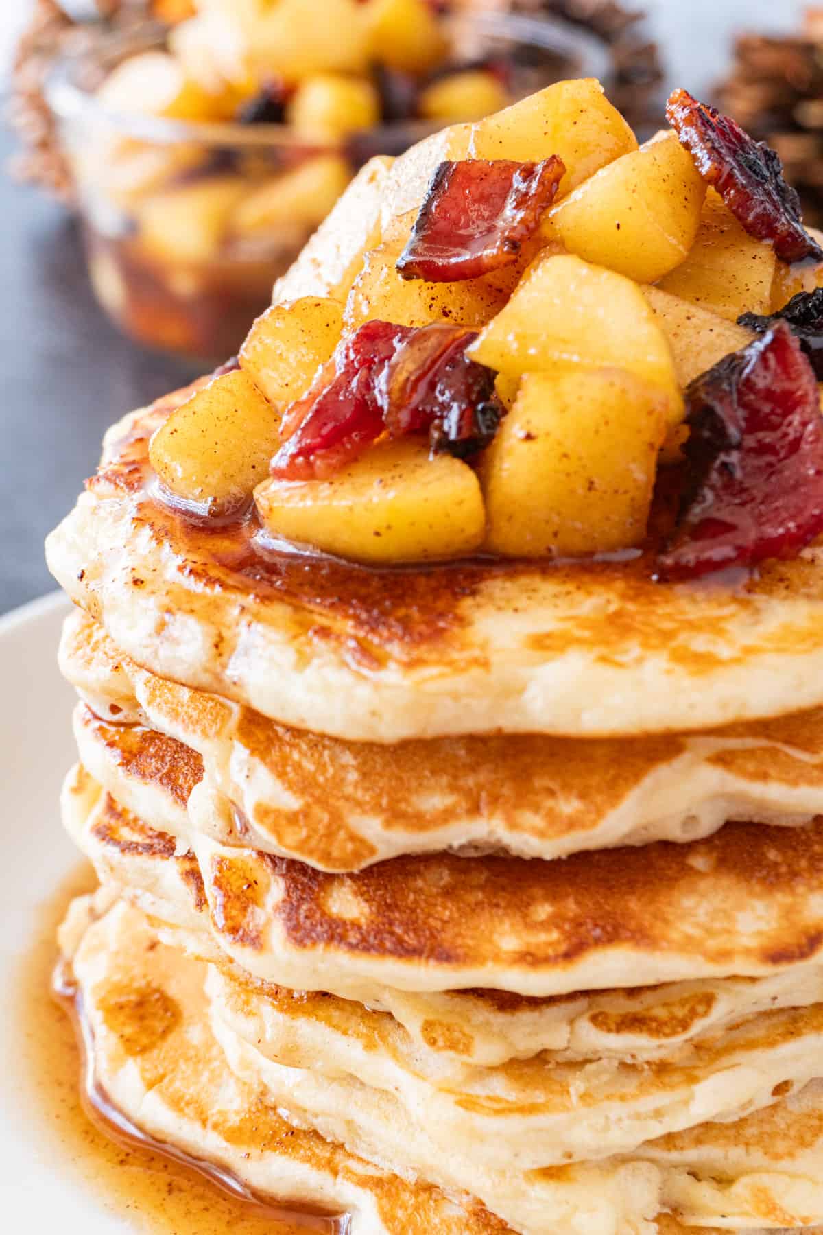 close up of stack of bacon pancakes with topping