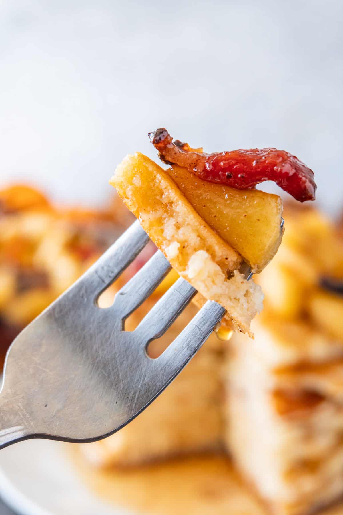 piece of pancake apple and bacon on fork
