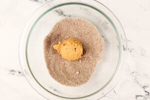 cookie being rolled in sugar mixture