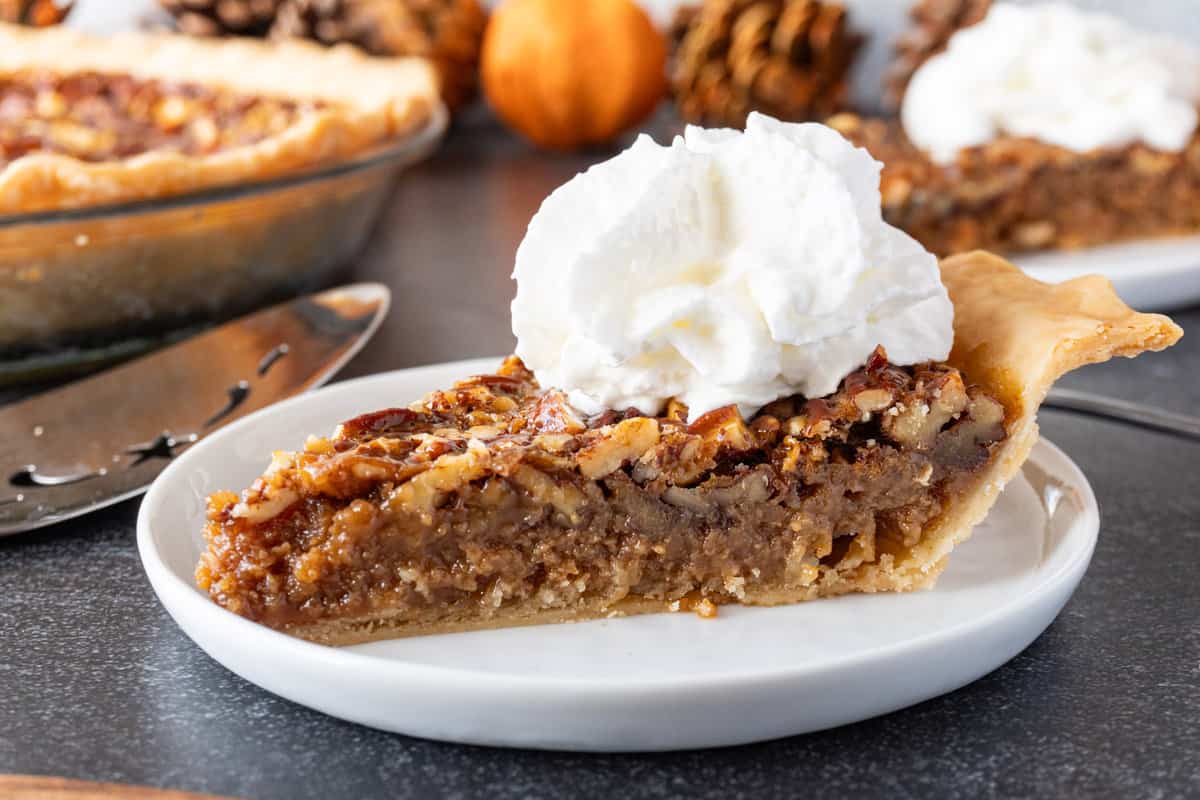 caramel pecan pie on plate with whipped cream
