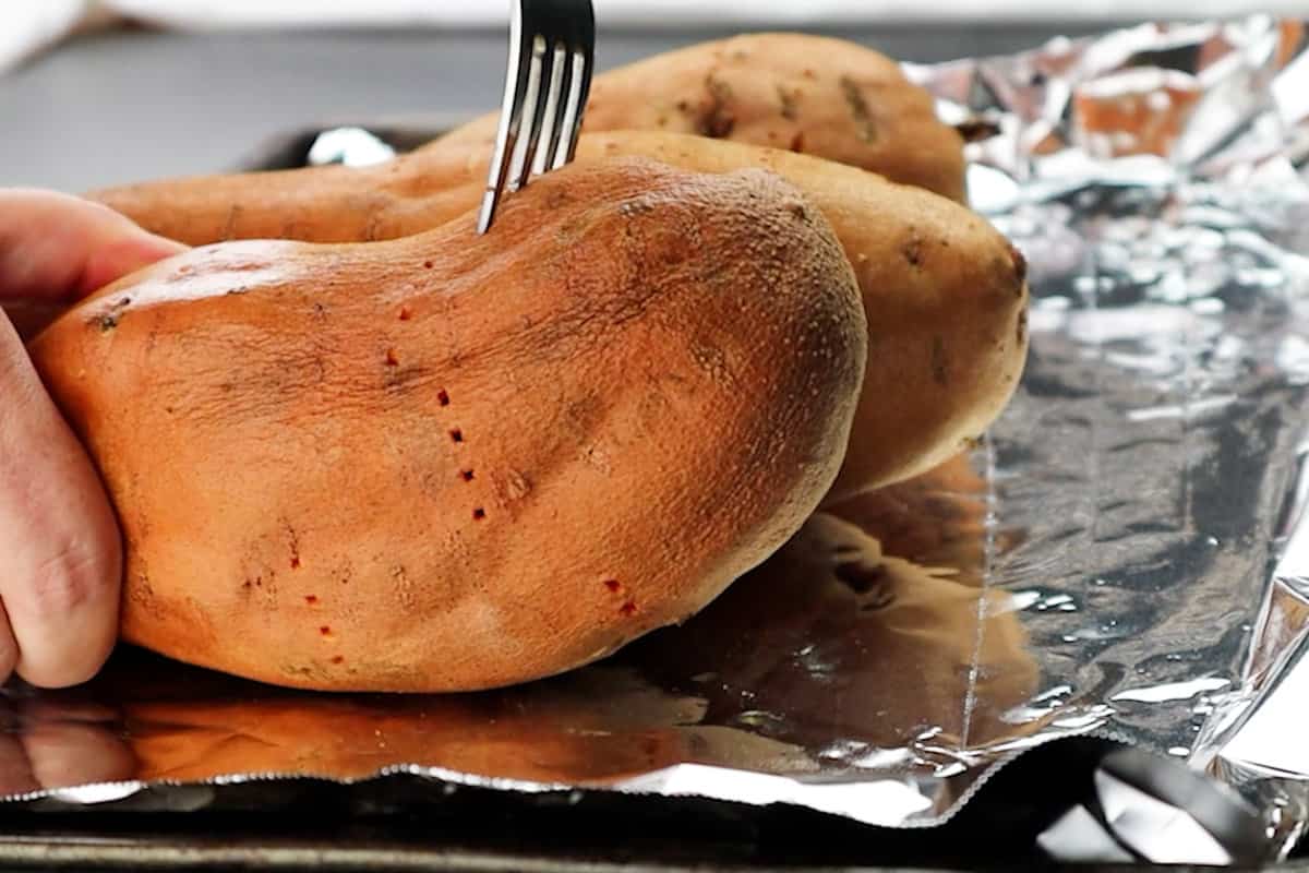 piercing uncooked sweet potatoes with fork