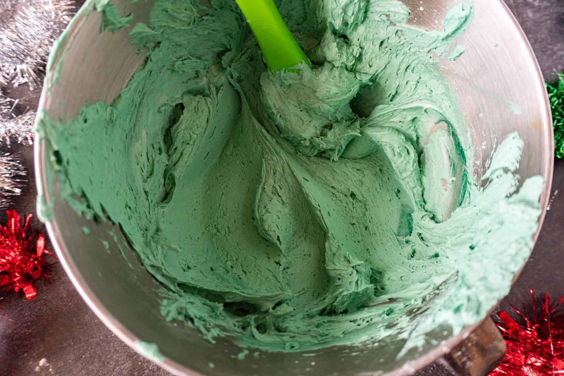 Green Buttercream frosting in metal mixing bowl.