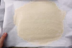dough rolled flat between parchment paper