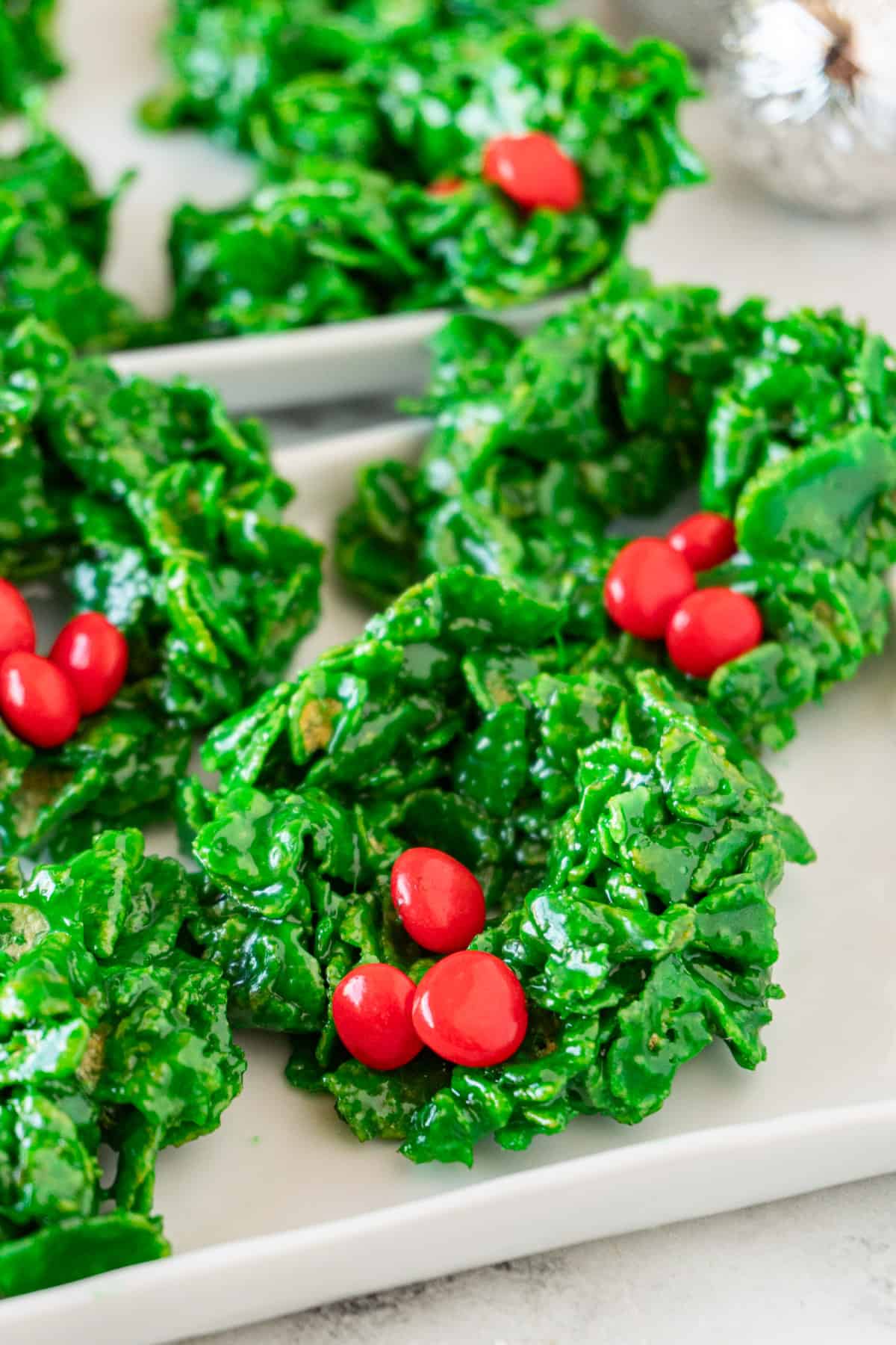 Christmas Wreath Cookies on white tray, displaying bright green color and red candies.