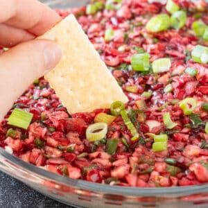 dipping a cracker into the Cranberry Jalapeno Dip