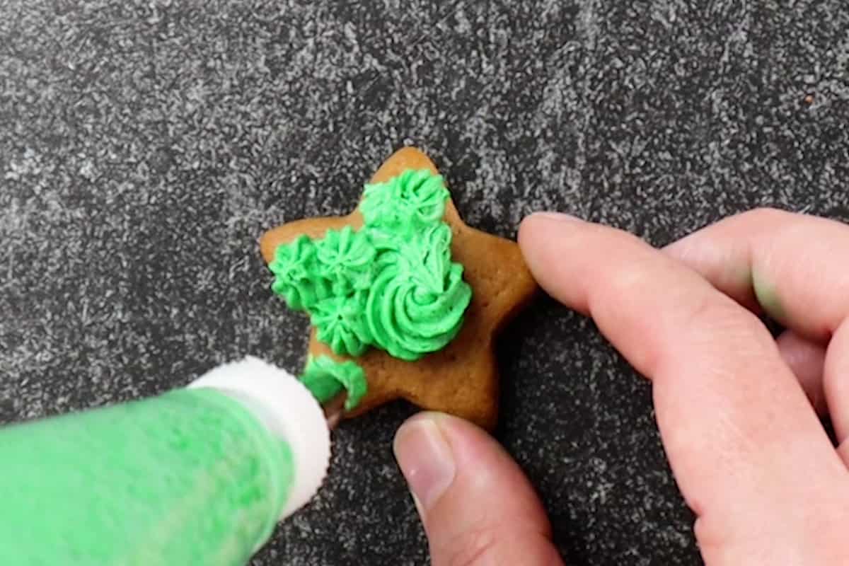 frosting a cookie with green frosting