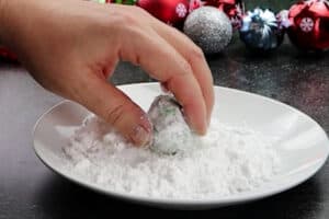 rolling cookie dough in powdered sugar