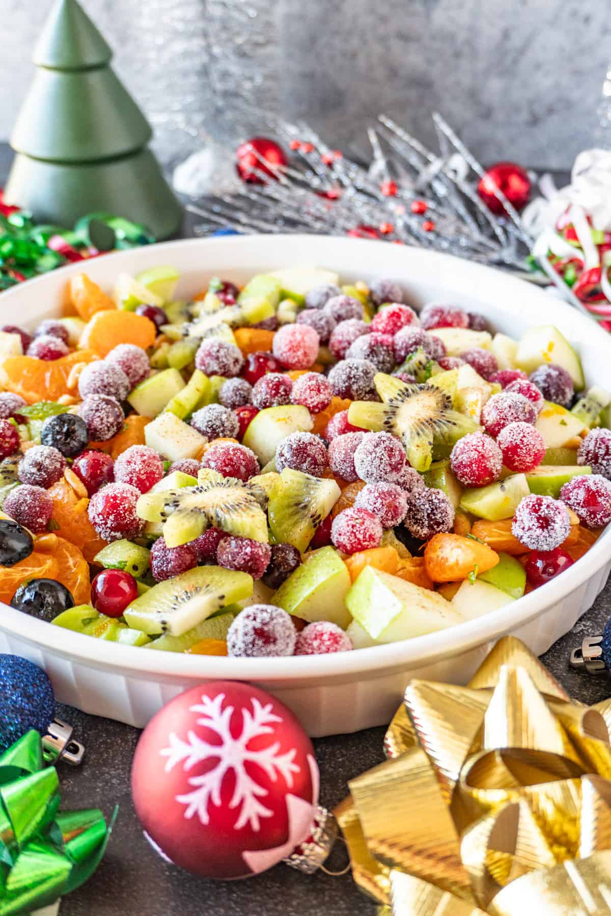 Christmas fruit salad in bowl with Christmas decorations around it
