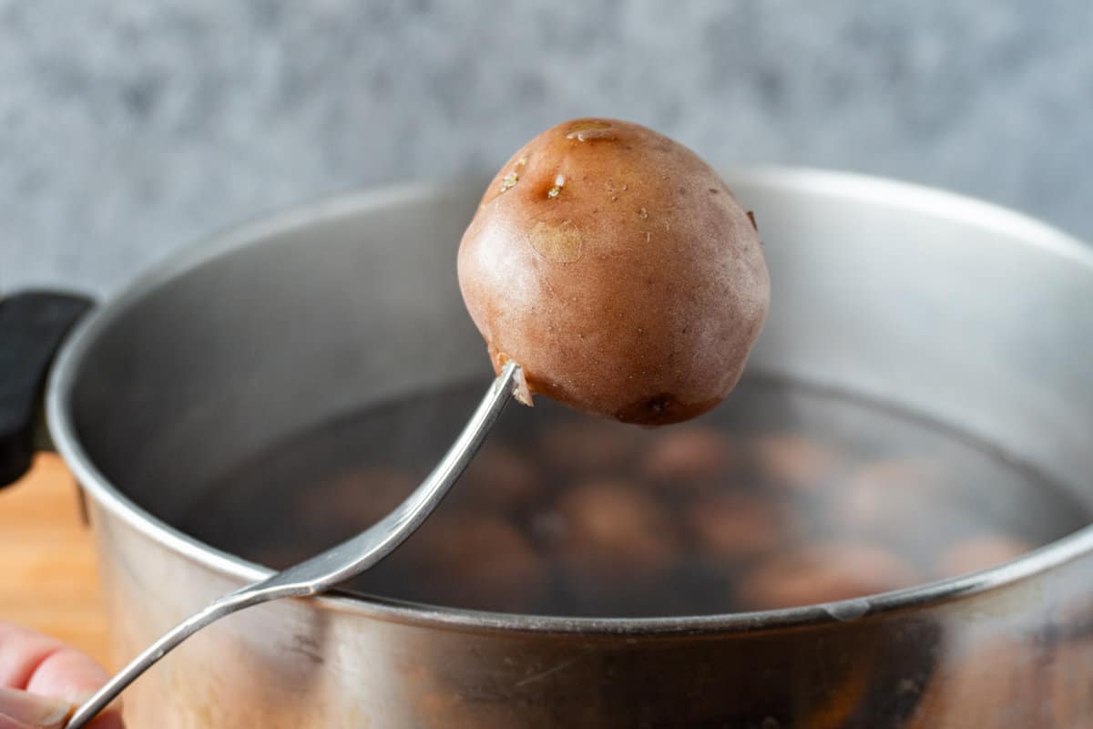 piercing a cooked potato with fork
