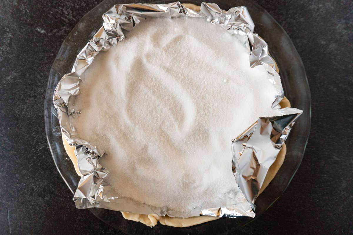 sugar weighing down foil in pie dish