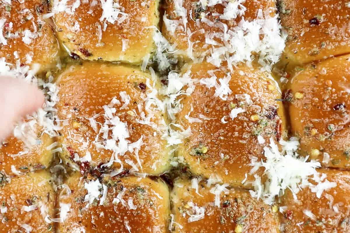 sprinkling parmesan on top of rolls