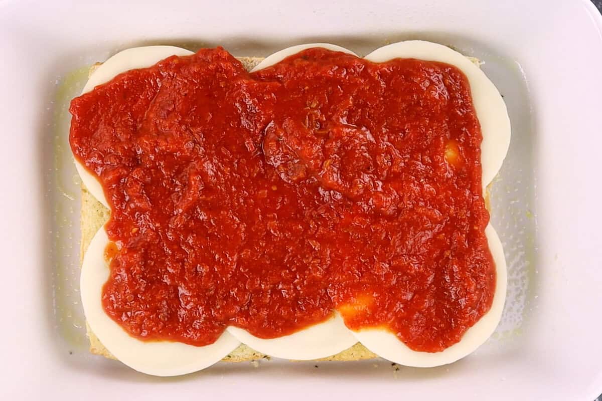 adding marinara on top of cheese