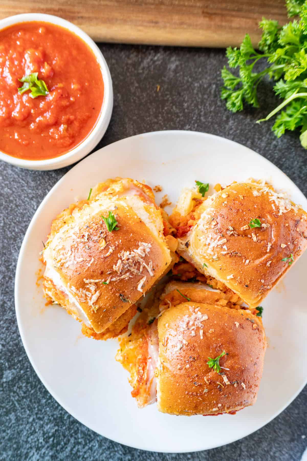 chicken parm slider close up of golden top with marinara in bowl to the side