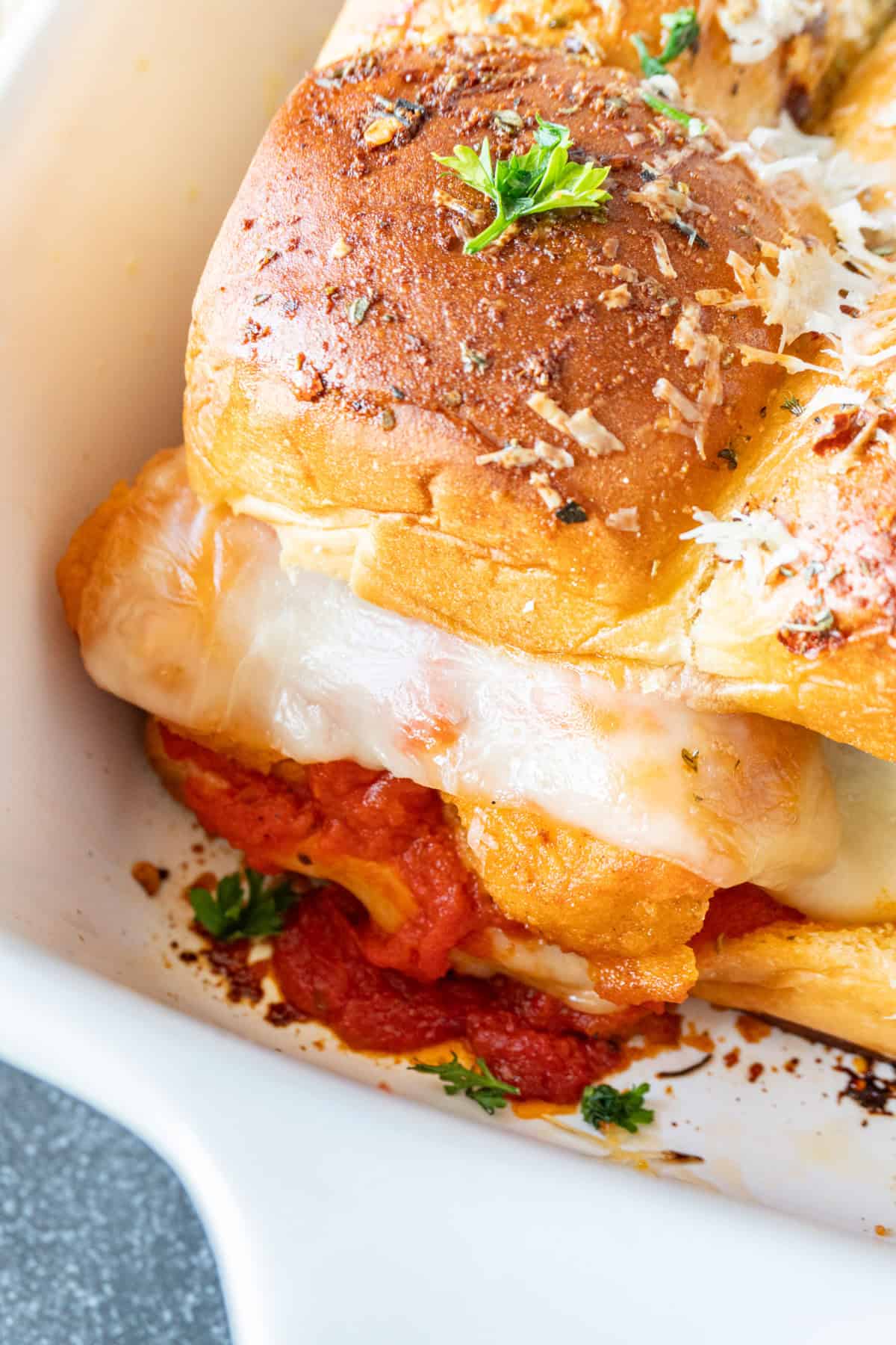 close up of chicken parm slider in baking dish