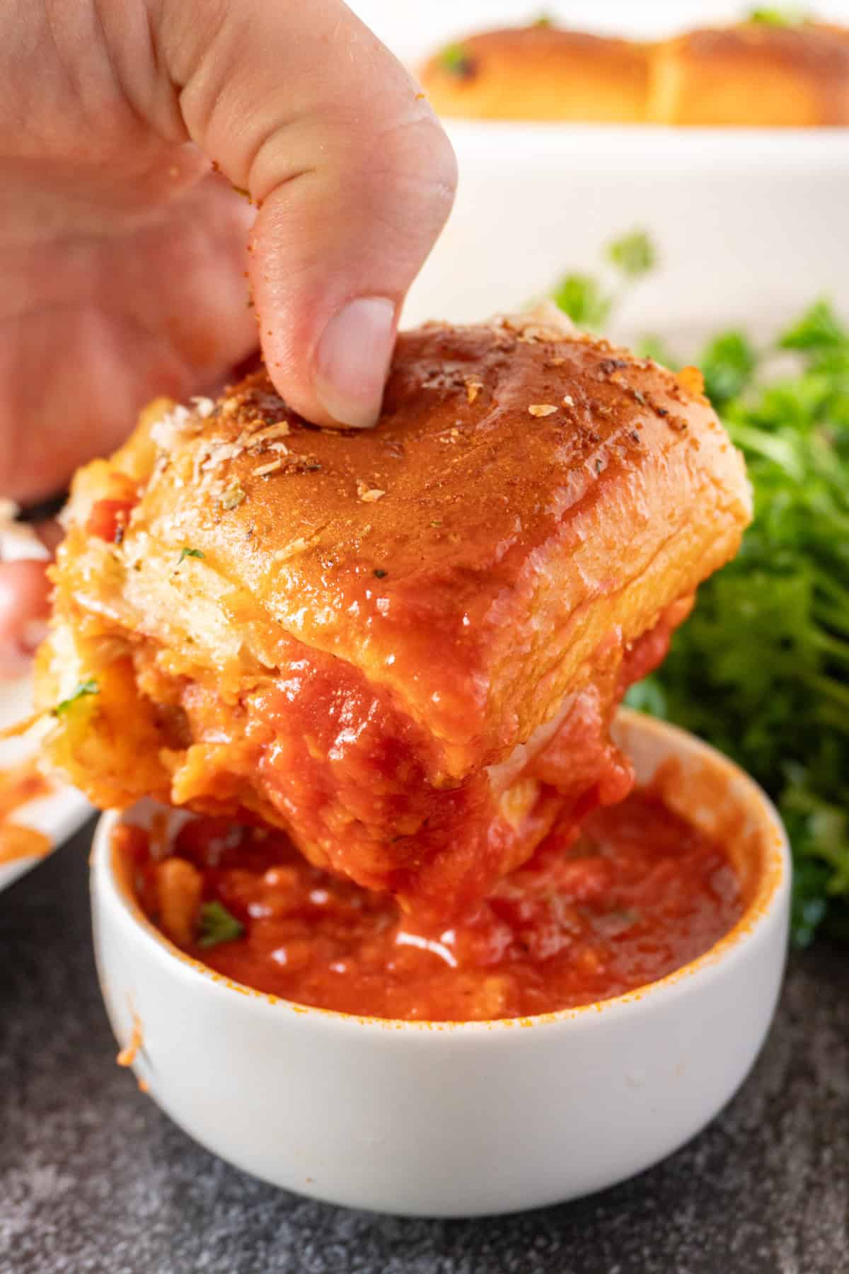 dipping chicken parm slider in extra marinara sauce