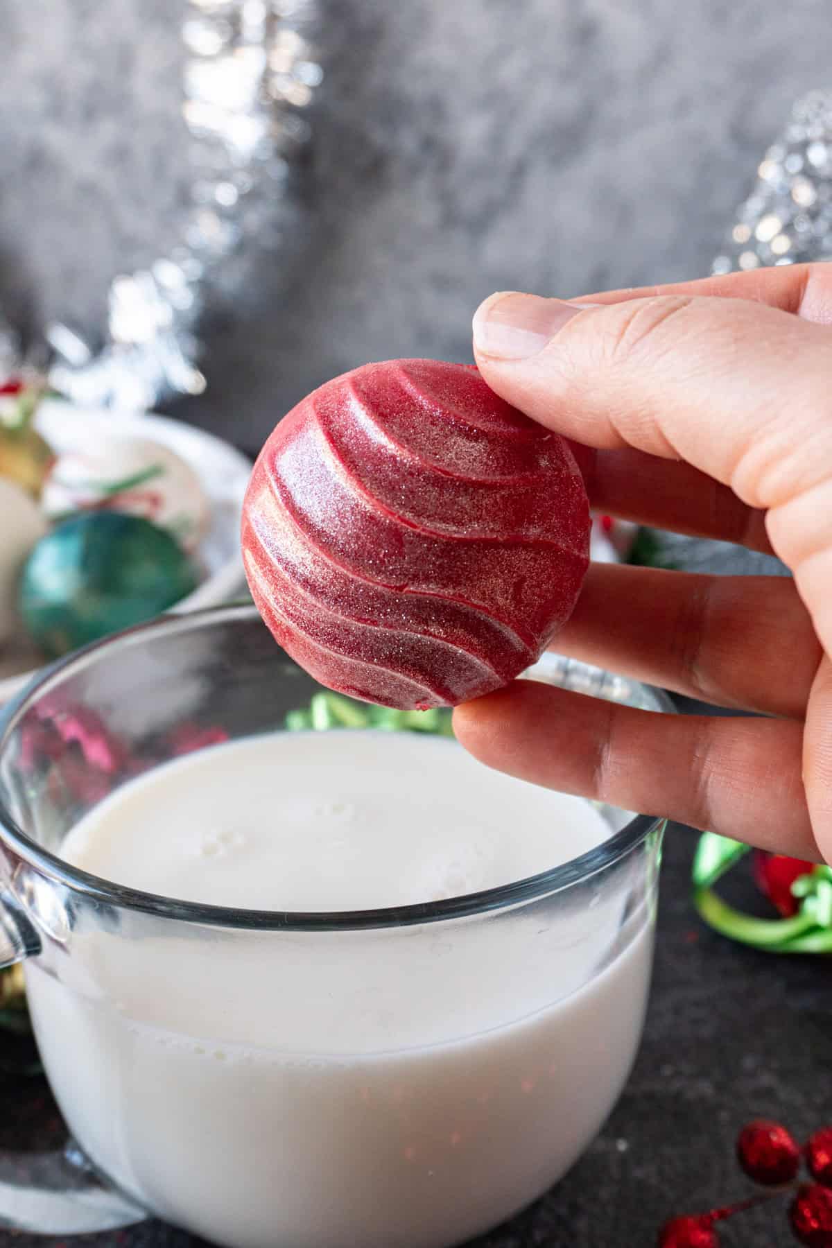 placing hot cocoa bomb into milk
